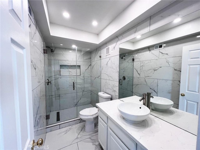 bathroom with vanity, a shower with door, tile walls, and toilet