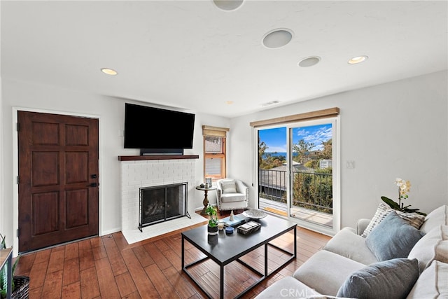 living room with dark wood-type flooring and a fireplace