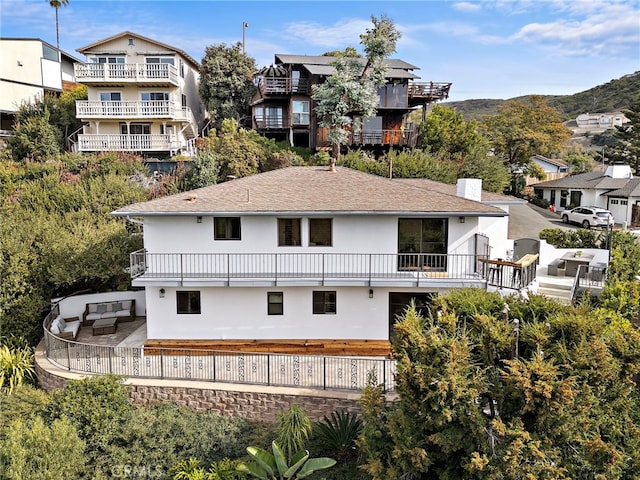 rear view of property with a patio and a balcony