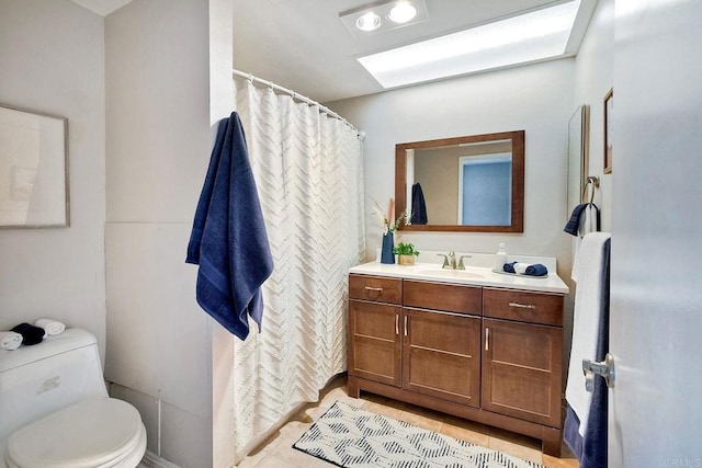 bathroom with tile patterned flooring, vanity, and toilet