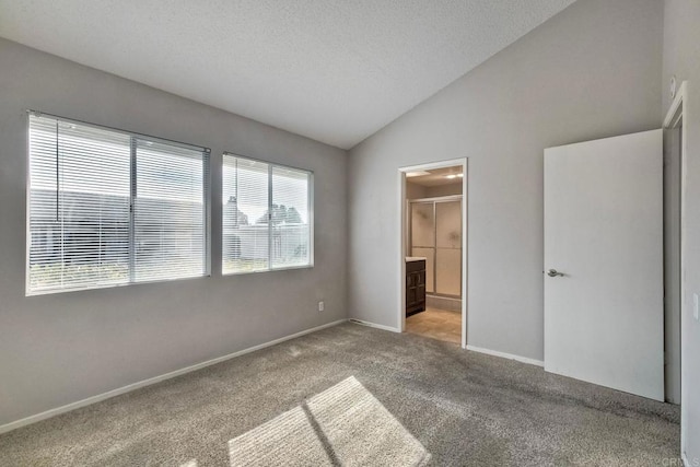 unfurnished bedroom featuring multiple windows, ensuite bathroom, light carpet, and a textured ceiling