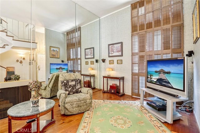 living room with hardwood / wood-style floors and a high ceiling