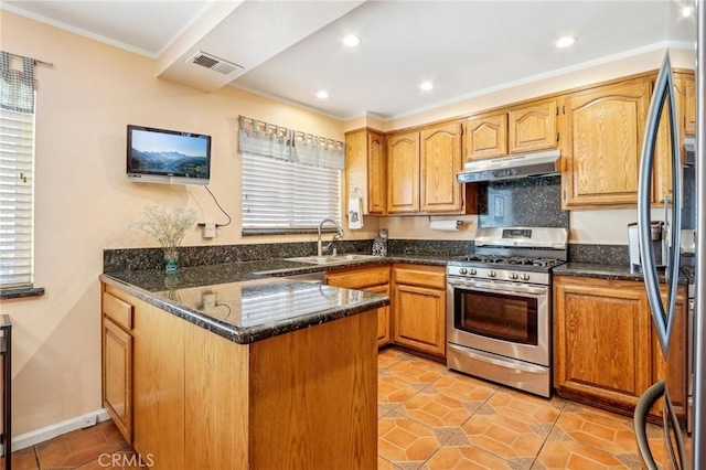 kitchen with sink, appliances with stainless steel finishes, kitchen peninsula, a wealth of natural light, and dark stone counters