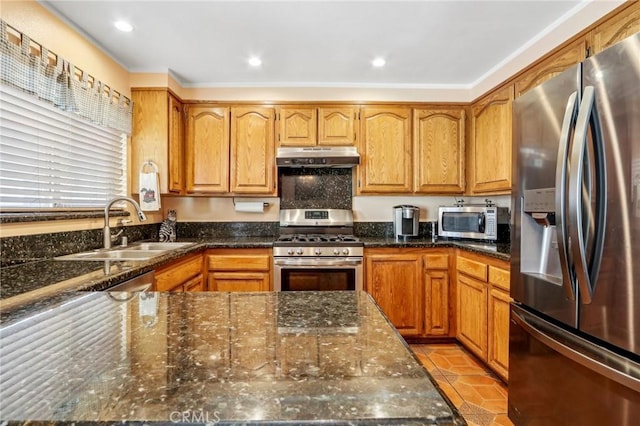 kitchen featuring appliances with stainless steel finishes, sink, light tile patterned floors, and dark stone counters