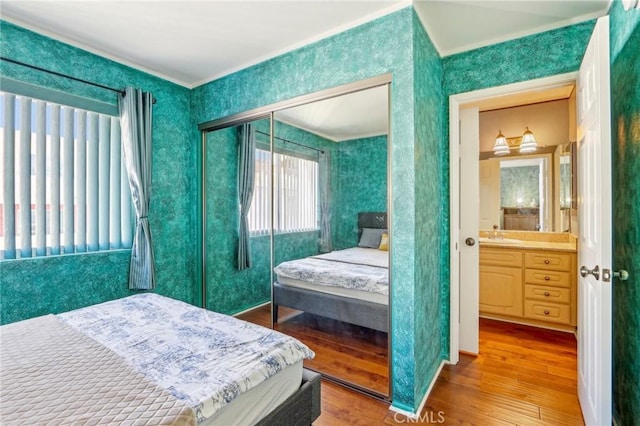 bedroom with hardwood / wood-style flooring, sink, and a closet