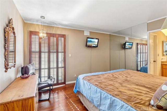 bedroom with a notable chandelier and dark hardwood / wood-style flooring