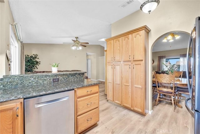 kitchen featuring light brown cabinetry, dark stone countertops, appliances with stainless steel finishes, ceiling fan, and light hardwood / wood-style floors