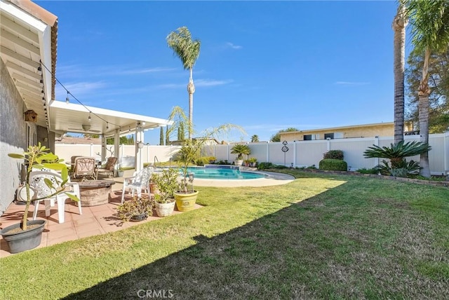 view of yard featuring a fenced in pool, a patio area, and a fire pit