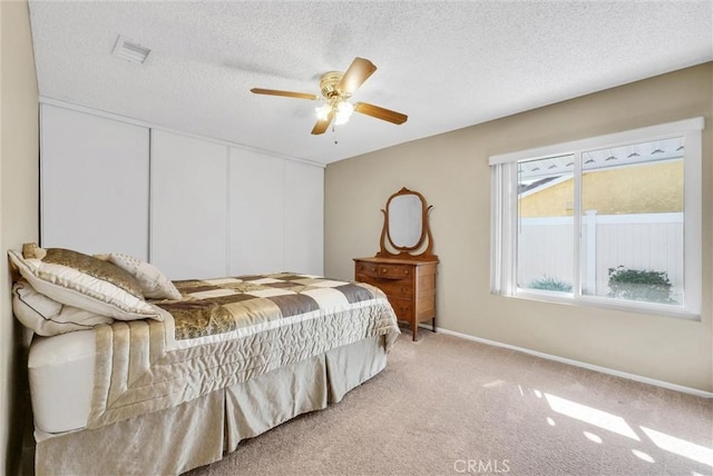 carpeted bedroom with a textured ceiling and ceiling fan