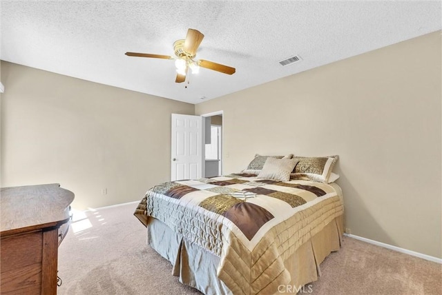 carpeted bedroom featuring a textured ceiling and ceiling fan