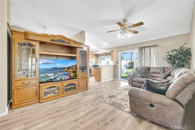 living room featuring vaulted ceiling, ceiling fan, and light hardwood / wood-style floors