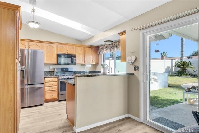 kitchen with lofted ceiling, decorative light fixtures, stainless steel appliances, and light hardwood / wood-style floors