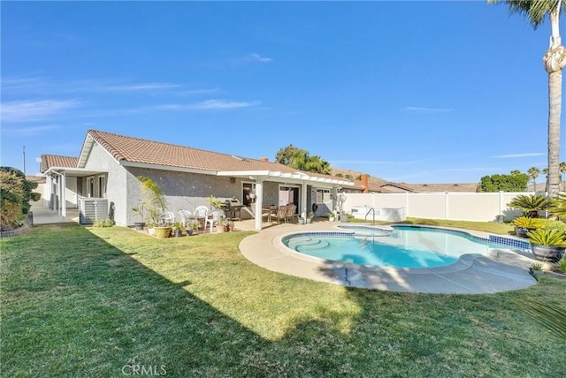 view of pool with a hot tub, a yard, and a patio area