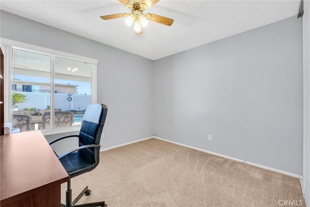 carpeted office featuring ceiling fan and a textured ceiling