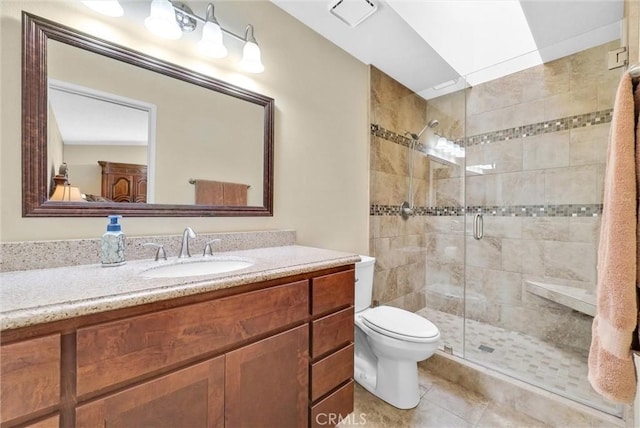 bathroom featuring a shower with door, vanity, tile patterned floors, and toilet