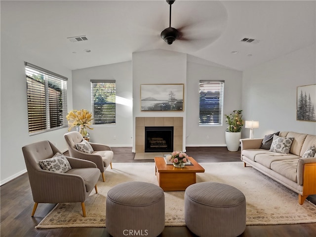 living room featuring dark wood-type flooring, ceiling fan, lofted ceiling, and a fireplace