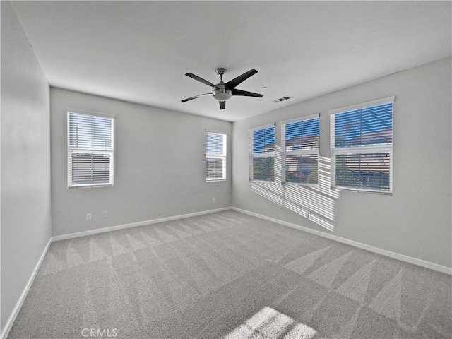 spare room featuring light colored carpet and ceiling fan