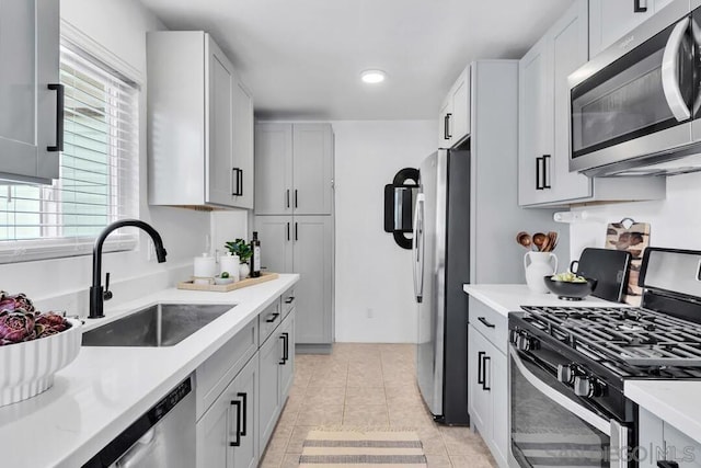 kitchen featuring stainless steel appliances, light tile patterned flooring, and sink