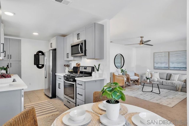 kitchen featuring light tile patterned flooring, appliances with stainless steel finishes, gray cabinetry, and ceiling fan