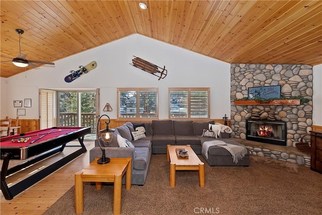 carpeted living room featuring a stone fireplace, wooden walls, high vaulted ceiling, billiards, and wood ceiling