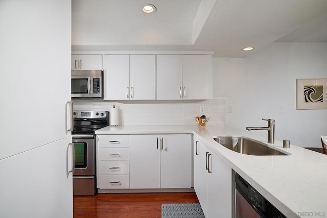 kitchen featuring sink, white cabinetry, backsplash, stainless steel appliances, and dark hardwood / wood-style floors