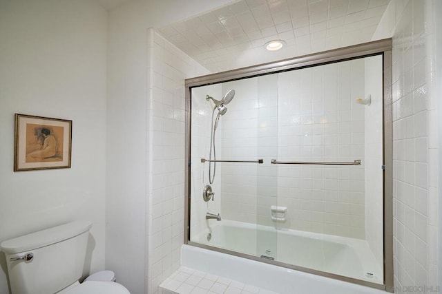 bathroom with toilet and combined bath / shower with glass door