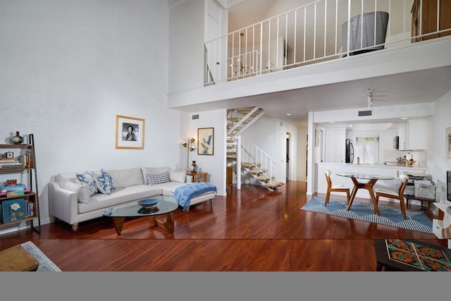 living room with hardwood / wood-style flooring and a towering ceiling