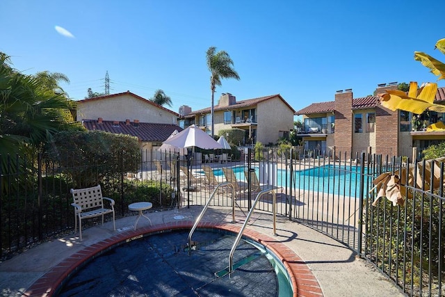 view of swimming pool featuring a patio and a community hot tub