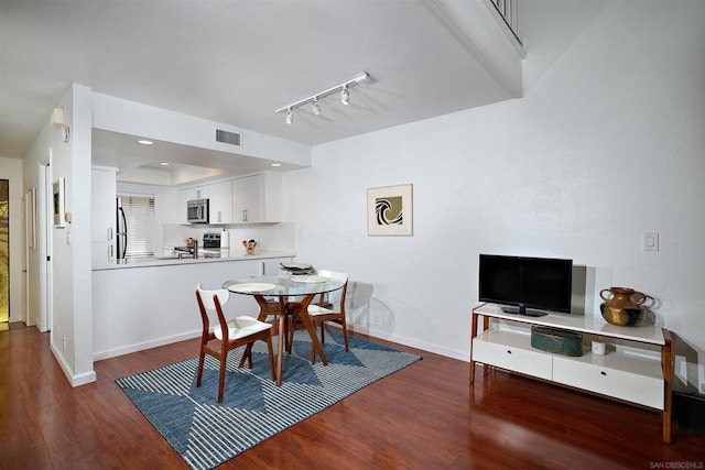 dining area featuring track lighting and dark hardwood / wood-style floors