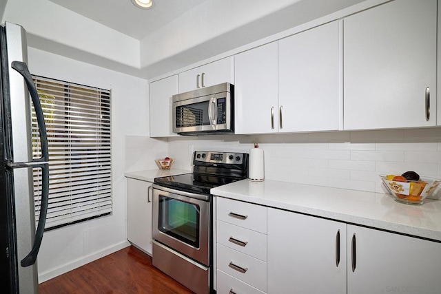 kitchen featuring white cabinetry, backsplash, dark hardwood / wood-style floors, and appliances with stainless steel finishes