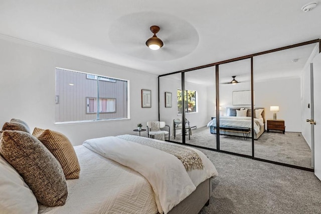 bedroom featuring carpet floors, ornamental molding, a closet, and ceiling fan