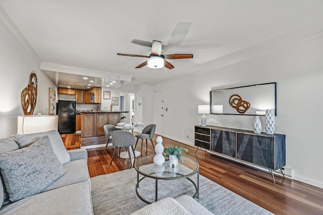 living room with crown molding, dark hardwood / wood-style floors, and ceiling fan