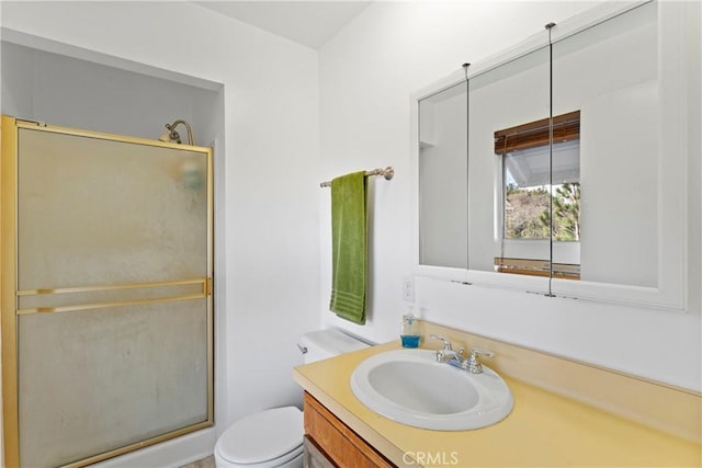 bathroom with vanity, toilet, and a shower with door