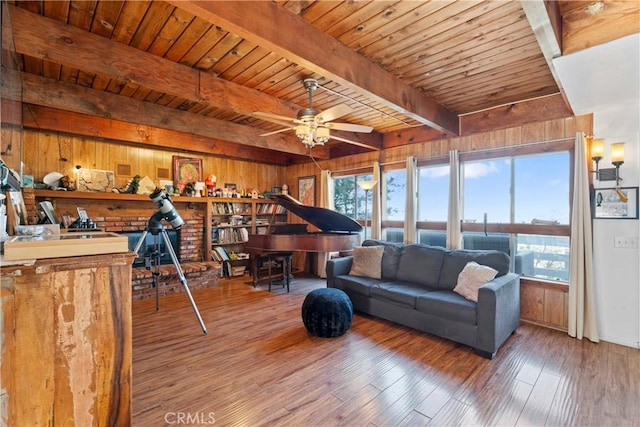 living room with beamed ceiling, a wealth of natural light, and wood walls