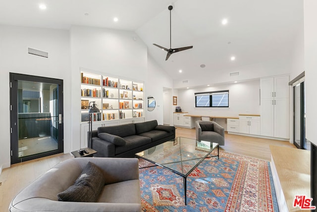 living room with built in features, high vaulted ceiling, light hardwood / wood-style floors, and ceiling fan