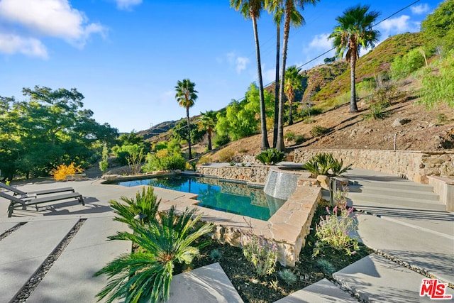 view of pool with a mountain view and a patio area