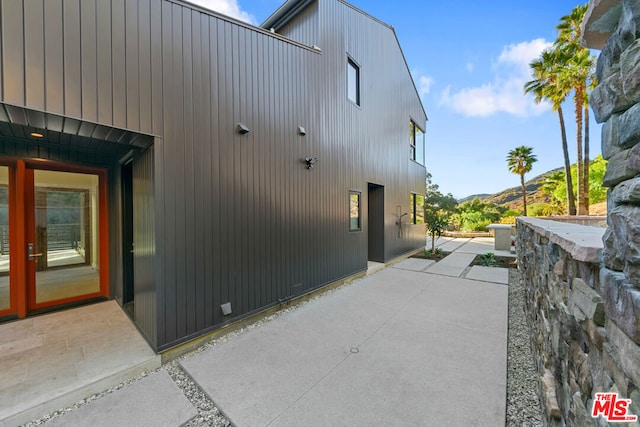 view of home's exterior with a mountain view and a patio area