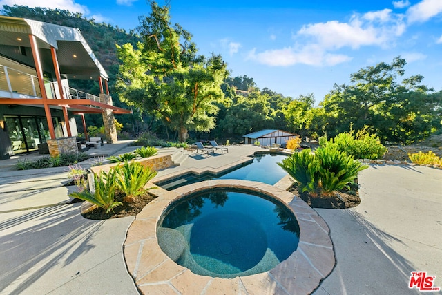 view of pool featuring an in ground hot tub and a patio area