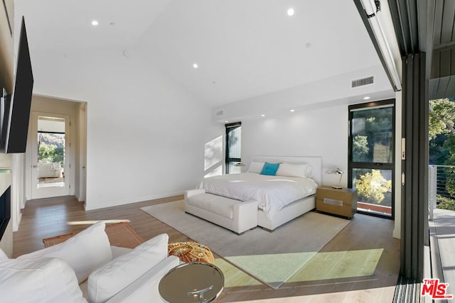 bedroom featuring hardwood / wood-style floors and high vaulted ceiling