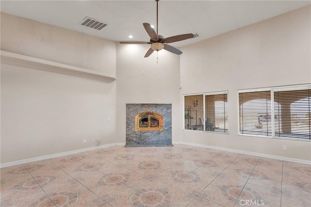 unfurnished living room featuring a premium fireplace and ceiling fan