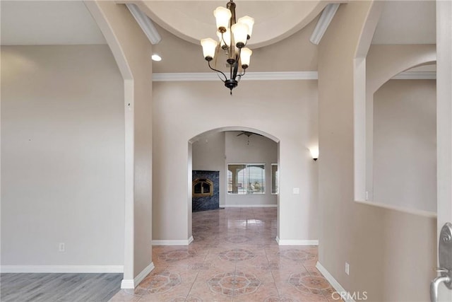 hallway with ornamental molding and a chandelier