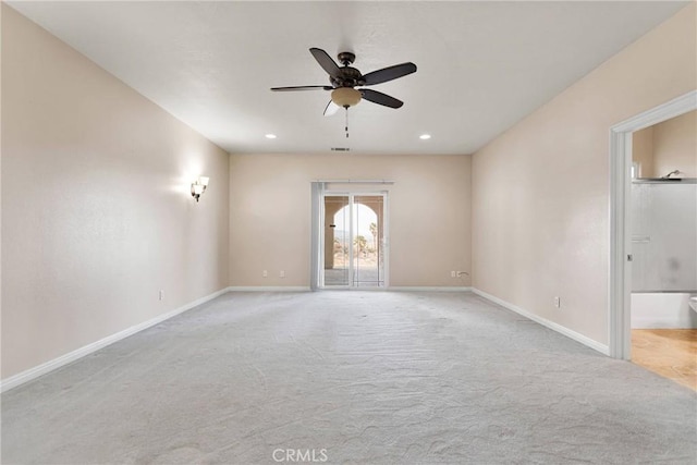 empty room featuring ceiling fan and light carpet