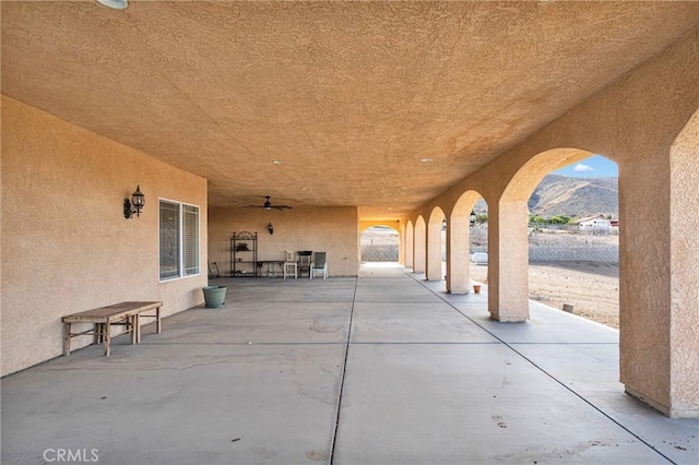 view of patio with ceiling fan and a mountain view