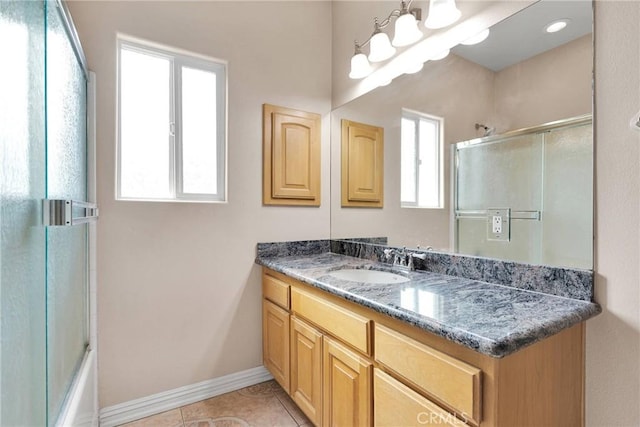 bathroom with tile patterned flooring, vanity, combined bath / shower with glass door, and a chandelier