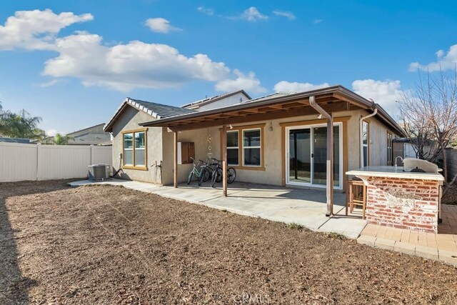 back of house featuring central AC, an outdoor bar, and a patio area