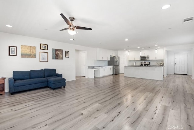 living room featuring ceiling fan and light hardwood / wood-style floors