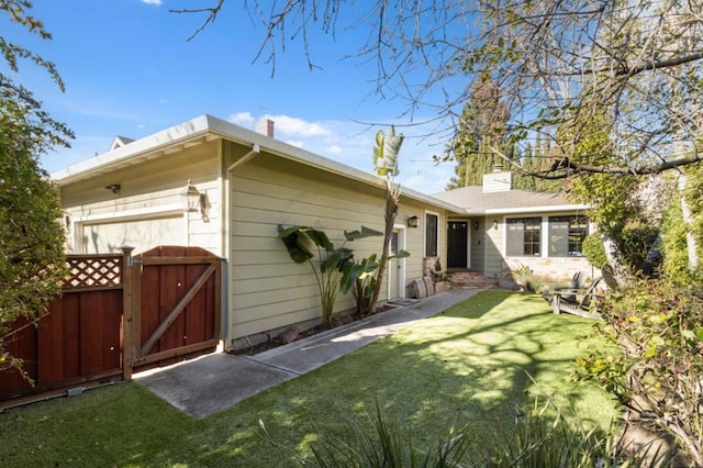 back of house featuring a yard and a garage