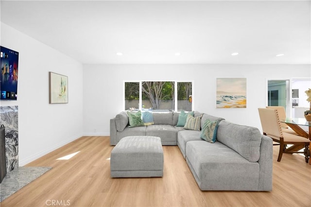 living room featuring light wood finished floors, baseboards, and recessed lighting