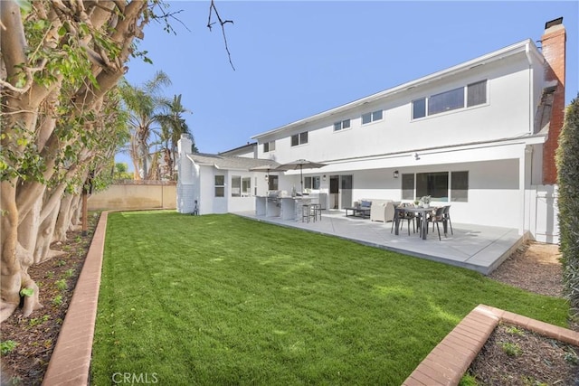 rear view of house with a patio area and a lawn