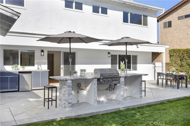 view of patio / terrace with a bar, a grill, and exterior kitchen